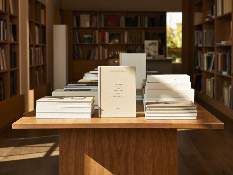 Masă de librărie din lemn cu cărți și caiete cu copertă goală, în lumină caldă